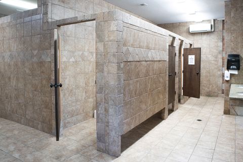 Inside a University Station bath house: tiled private stalls and a tiled floor