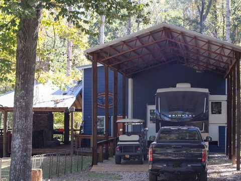A blue cabin-style site with a metal roof, an RV and a golf cart