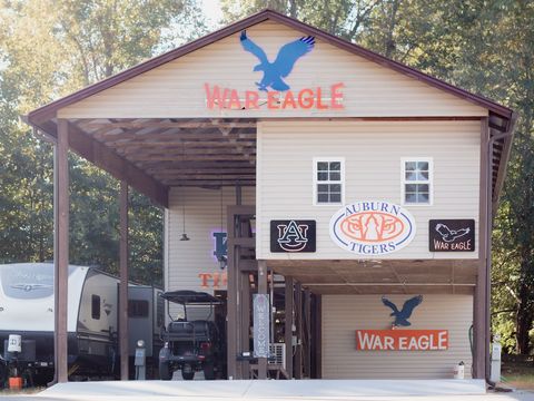 A two-story, Auburn-themed pavilion at an RV site, with flags flying